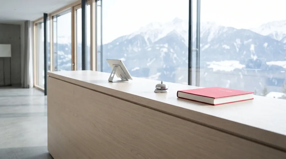 La reception di notte, neve oltre la porta, il telefono con la luce rossa.